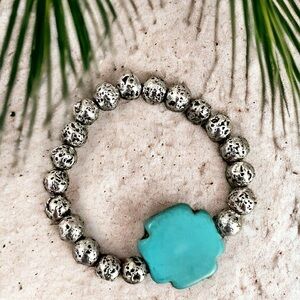 AGIA BRACELET Featuring a genuine turquoise howlite cross on silver lava stone